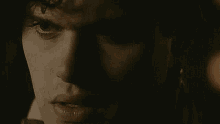 a close up of a woman 's face in the dark with a serious look on her face .