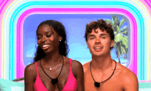 a man and a woman are posing for a picture in front of a rainbow