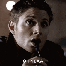 a man is holding a lollipop in his mouth and says oh yeaa