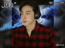 a man wearing headphones and a plaid shirt with the year 2024.12.31 on the bottom