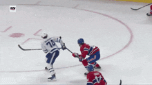 a hockey player with the number 74 on his jersey is getting ready to shoot the puck