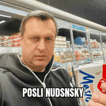 a man is holding a carton of milk in a grocery store and making a funny face .