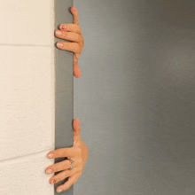 a woman 's hand with a ring on her finger is reaching for a door