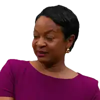 a woman wearing a purple dress and earrings looks at the camera