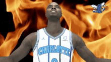 a man in a charlotte jersey stands in front of a fire background