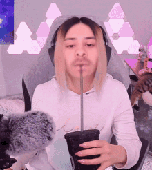 a man with a straw in his mouth is holding a cup