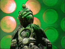 a green monster is sitting in front of a green background with circles