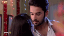a man and a woman are kissing with a hotstar logo in the background