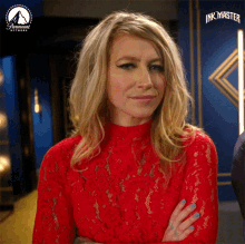 a woman in a red lace top is standing in front of a paramount network sign