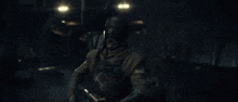 a man is holding a gun in his hand in a dark room with a lot of fire coming out of it .