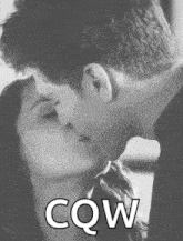 a man and a woman are kissing in a black and white photo with the words `` cow '' written below them .