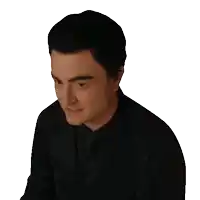 a man in a black suit and tie is looking to the side