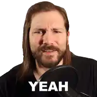 a man with long hair and a beard says " yeah " in front of a microphone