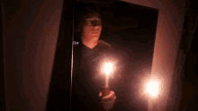 a person holding a light in front of a mirror