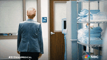 a woman in a blue jacket is standing in a room with nbc written on the bottom right