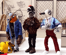 three stuffed birds are standing in front of a wall that has graffiti on it that says philadelphia