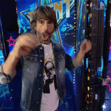 a man in a denim jacket is standing in front of a sign that says " talent "