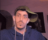a man wearing a hat and ear buds has the number 76 on his shirt