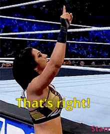 a woman is standing in a wrestling ring giving a thumbs up and saying that 's right !