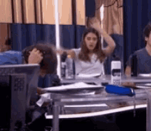 a group of people are sitting at a table with a water bottle that says ' g ' on it
