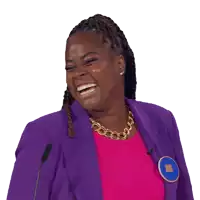 a woman wearing a purple jacket and a pink top is laughing