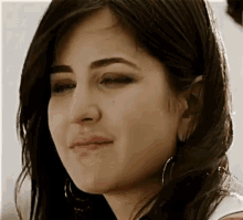 a close up of a woman 's face with a tear coming out of her eye