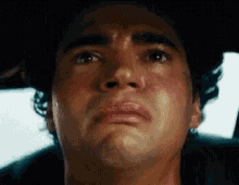 a close up of a man 's face with a tear running down his cheek .