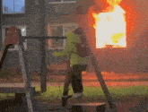 a person sitting on a swing in front of a fire