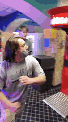 a man wearing a harley davidson shirt is standing in front of a boxing machine