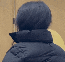 the back of a woman 's head is shown in a close up of a black jacket .