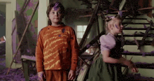 a boy and a girl are standing next to each other with purple paint on their clothes