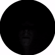 a black circle with a purple face in the center