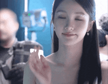 a woman with her eyes closed looks at the camera with a smile on her face