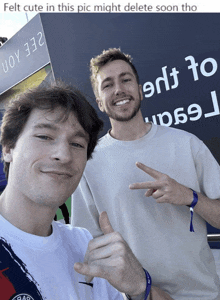 two men standing in front of a sign that says uoy 332
