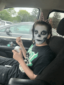 a boy with a skeleton face painted on his face