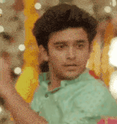 a young man in a green shirt is making a funny face while dancing .