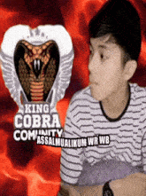 a boy is sitting in front of a king cobra logo