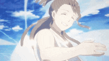 a woman is standing in front of a blue sky with her arms outstretched and smiling .