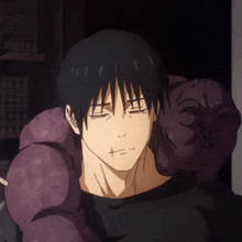 a man in a black shirt is holding a purple monster on his shoulder .