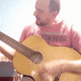 a man playing a guitar with a shirt that says yoaeni