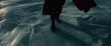 a person in a red cape walking on a snowy surface