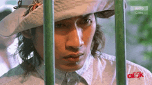a man wearing a white hat and a white shirt is behind a fence that says astro on it