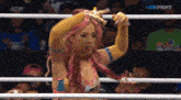 a woman is standing in a wrestling ring holding a sword .