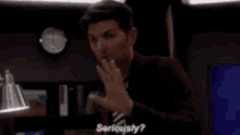 a man in a suit and tie is making a gesture with his hand and says `` seriously '' .