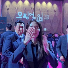 a woman covering her face with her hand in front of a sign that says 456