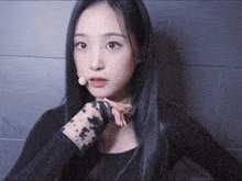 a woman with long black hair is wearing a black shirt with a leopard print sleeve