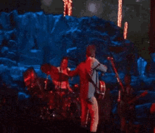 a group of people playing instruments on a stage with lights in the background