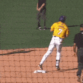 a baseball player wearing a yellow jersey with the number 7