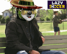 a man wearing a sombrero is sitting on a bench with lazy soccer written in the background