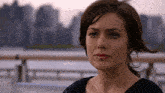 a close up of a woman with a city in the background